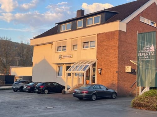 Außenansicht des Hotel Bevertal mit Parkplatz und Banner