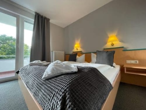 Modernes Hotelzimmer mit Doppelbett und Balkon