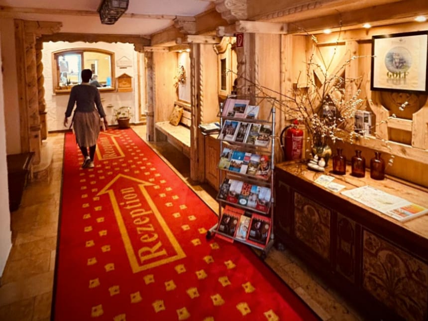 Hotelflur mit rotem Teppich und Rezeption