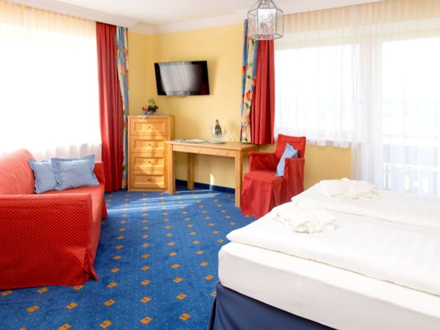 Komfortables Hotelzimmer mit Doppelbett und Balkonblick