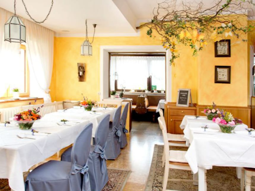 Gemütliches Restaurant mit elegant gedeckten Tischen und Blumenarrangements.