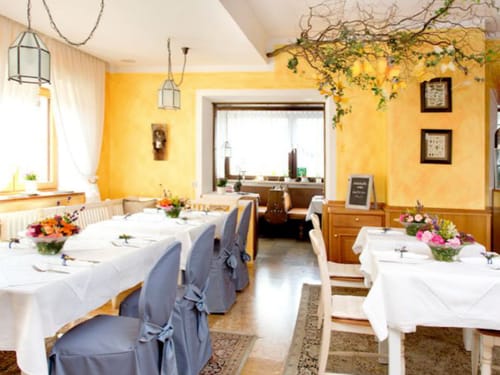 Gemütliches Restaurant mit elegant gedeckten Tischen und Blumenarrangements.