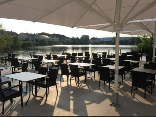 verschiedene Sitzgruppen mit Sonnenschirm auf der Seeterasse