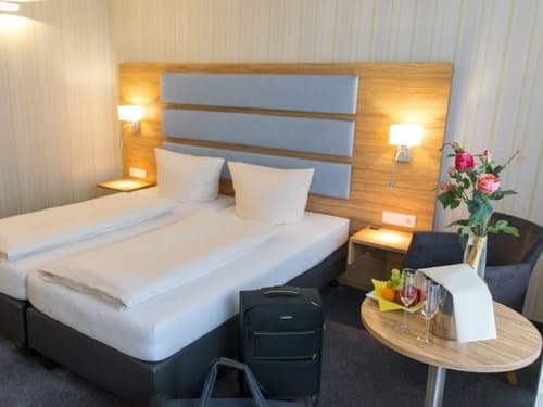 Doppelzimmer Standard mit Doppbett, Sessel und Tisch