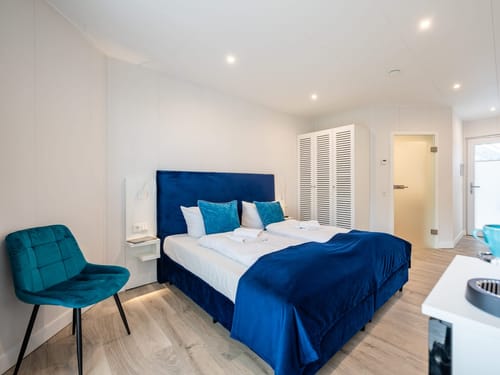 Boxspsringbett, Sessel, Sideboard und Kaffeezubereiter im Doppelzimmer