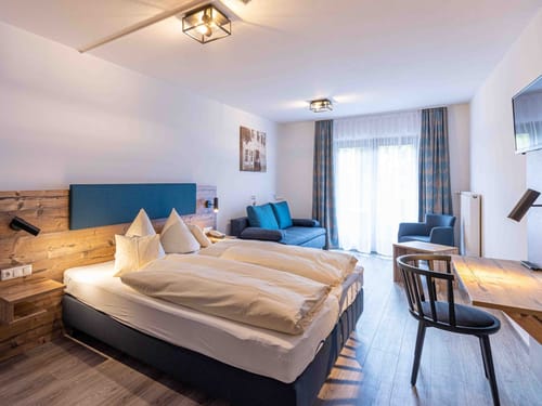 Helles Zimmer mit Coch,TV und einem Schreibtisch