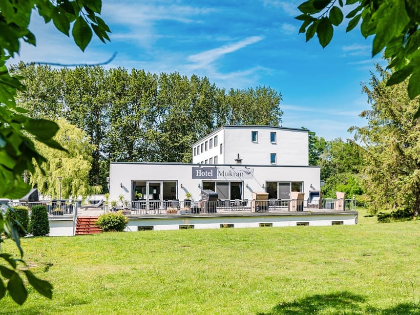 Hotelansicht vom Garten aus bei Sonnenschein