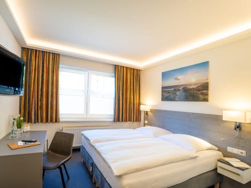 Hotelzimmer mit TV, Stuhl und einem Schreibtisch