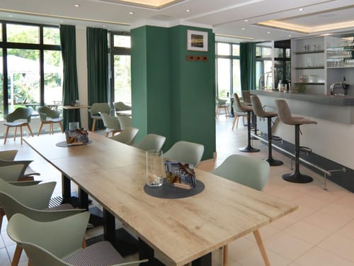 Einladender Gastraum mit zeitgemäßem Design, natürlichen Holzelementen und einer stilvollen Hotelbar