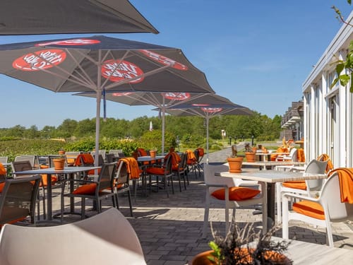 Sonnenterrasse mit verschiedenen Tischgruppen am Hotel