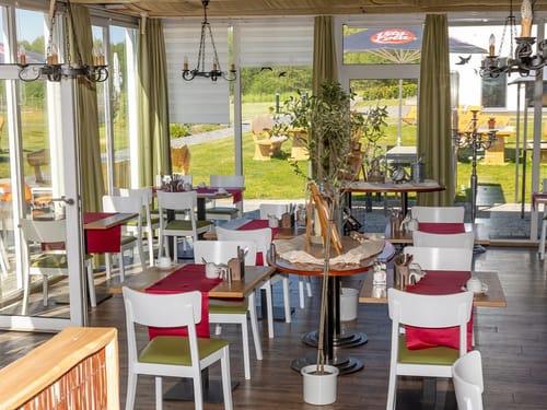 Hotelrestaurant mit kleinen Tischgruppen und Panoramafenstern