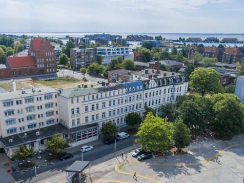 Luftaufnahme einer deutschen Stadt mit historischen und modernen Gebäuden in der Nähe eines Gewässers.