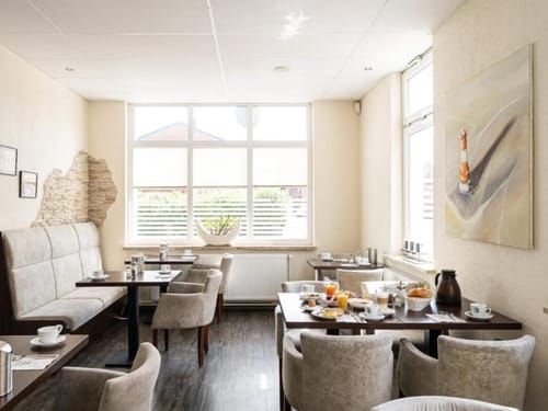 Gemütliches Cafe mit hellem Interieur und gedeckten Tischen für das Frühstück.