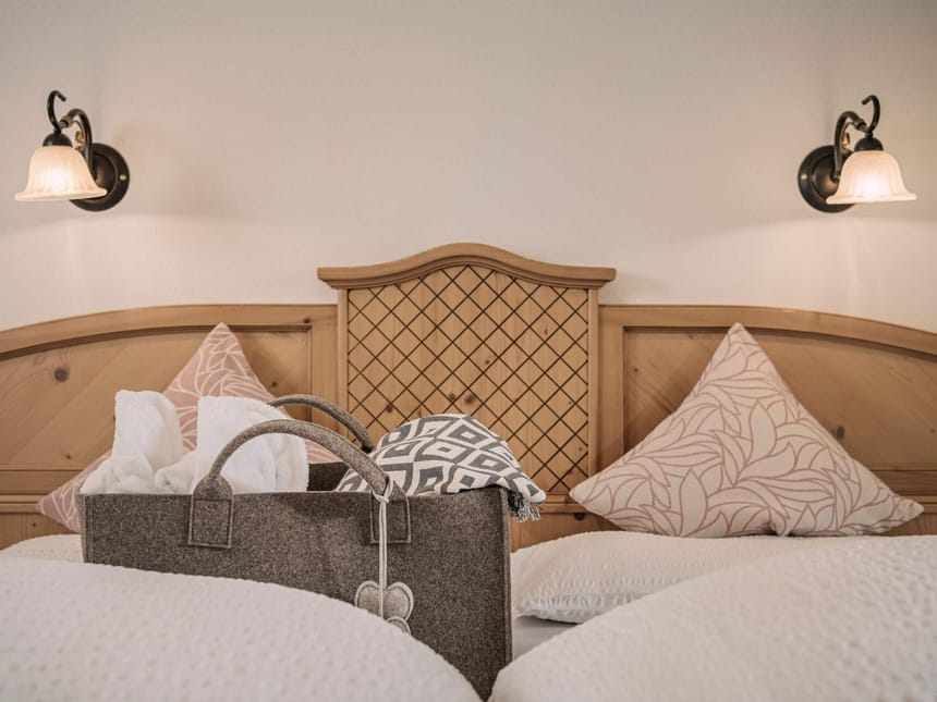 Gemütliches Hotelzimmer mit Holzbett und Dekokissen