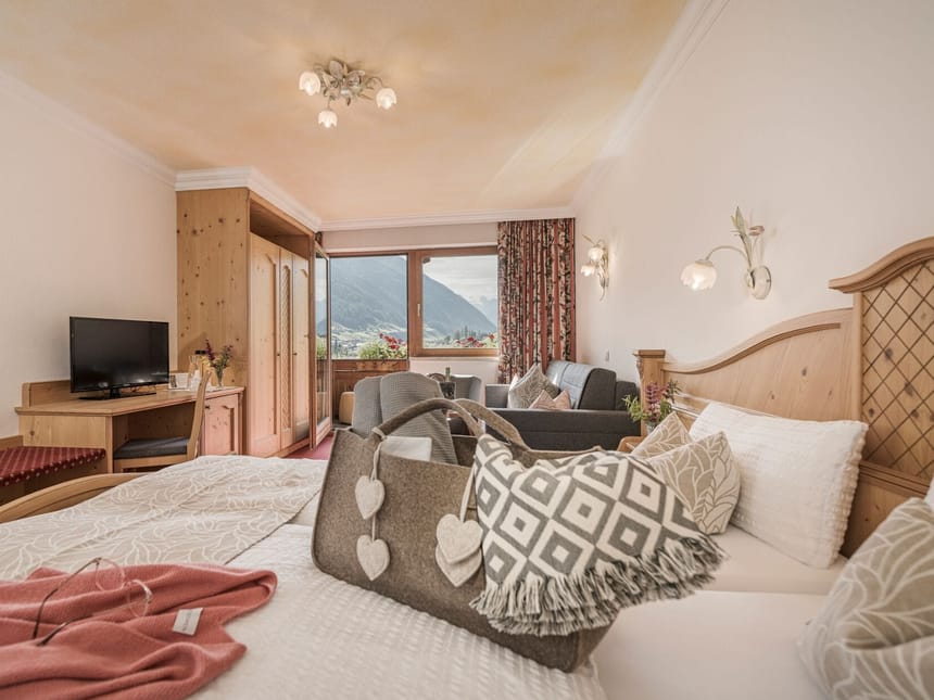Gemütliches Hotelzimmer mit Bergblick, traditioneller Holzeinrichtung und modernem Komfort.