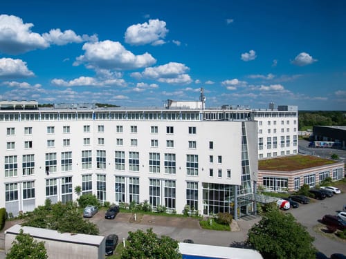 Modernes Geschäftsgebäude mit weißer Fassade unter blauem Himmel