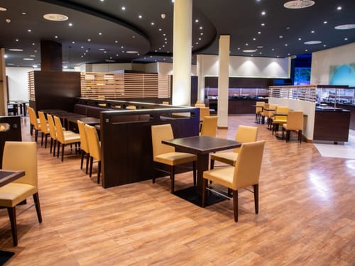 Modernes Restaurantinterieur mit hölzernem Boden und stilvollen Stühlen.