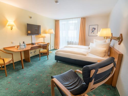 Gemütliches Hotelzimmer mit Doppelbett, Schreibtisch und TV