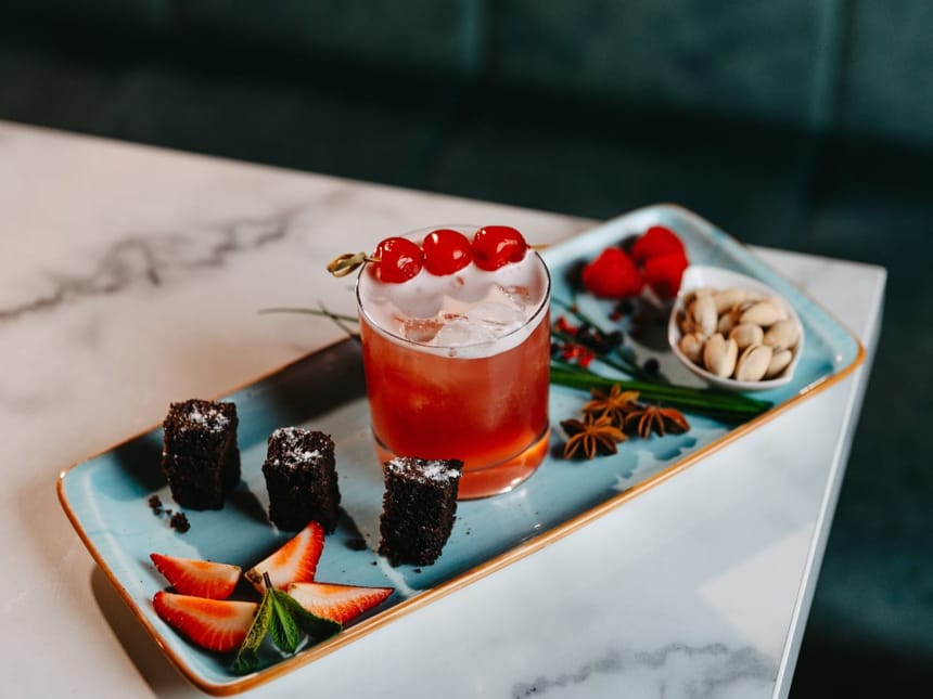 Eleganter Cocktail mit Beilagen auf einem Teller