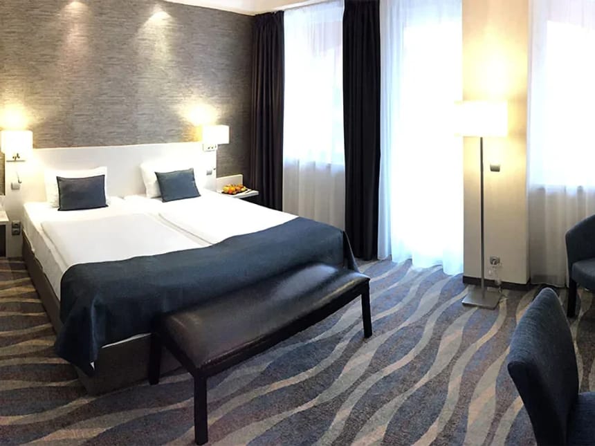 Komfortables Hotelzimmer mit Doppelbett, stilvoller Beleuchtung und moderner Einrichtung.