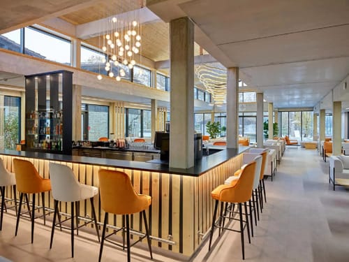 Entdecken Sie ein modernes Café mit eleganter Einrichtung, komfortablen Sitzgelegenheiten und einer stilvollen Bar. Perfekt für entspannte Treffen oder Kaffeepausen.