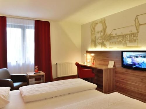 TV, Schreibtisch und eine kleine Sitzecke