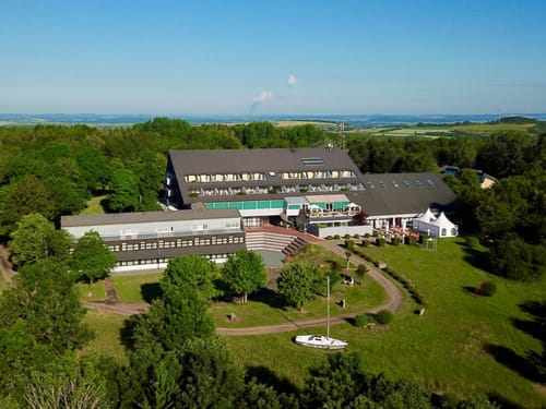 Luftaufnahme eines Hotels inmitten grüner Landschaft mit weiten Ausblicken.