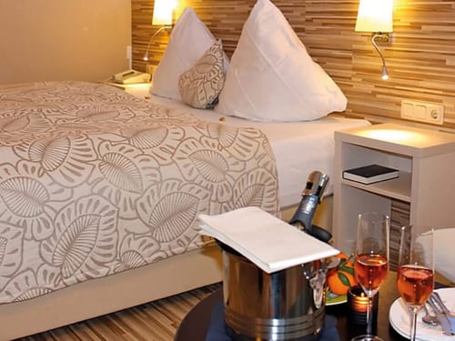 Gemütliches Hotelzimmer mit Doppelbett und Sekt