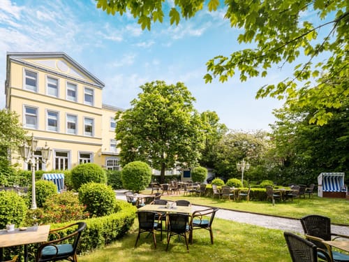 Schöner Garten eines Hotels mit Outdoor-Sitzbereich und grüner Umgebung