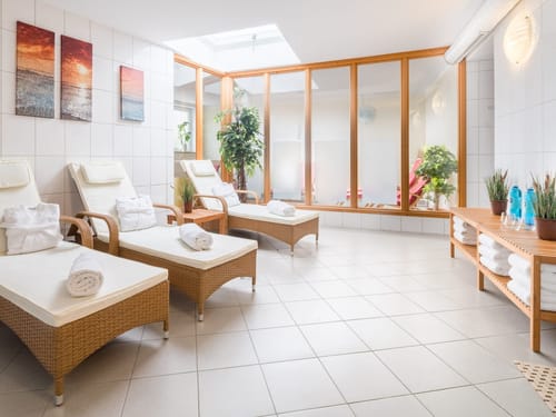 Helle Entspannungslounge mit Liegestühlen und Wellnesseinrichtung