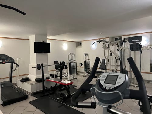Moderner Fitnessraum mit verschiedenen Trainingsgeräten.