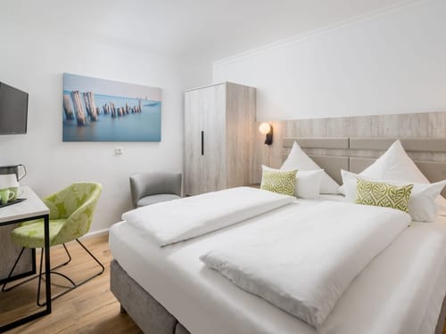 Modernes Hotelzimmer mit Doppelbett, stilvollem Dekor und Wandbild.