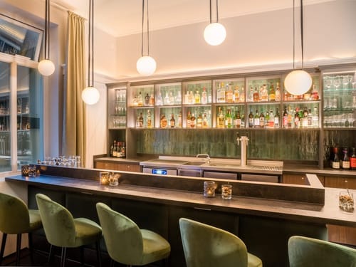 Moderne Bar mit eleganter Beleuchtung und gut bestücktem Regal.