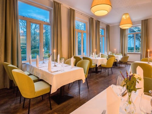 Elegantes Restaurant mit gedeckten Tischen und stimmungsvoller Beleuchtung