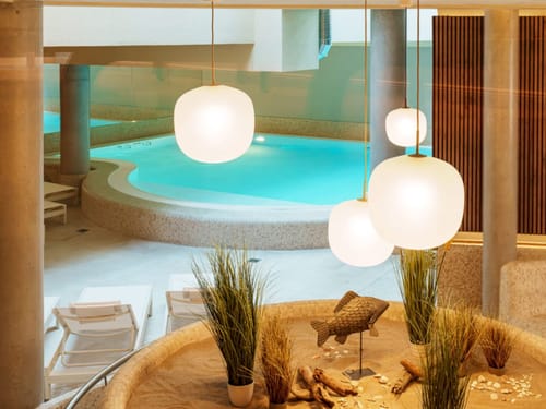 Eleganter Innenpoolbereich mit moderner Beleuchtung und Liegestühlen
