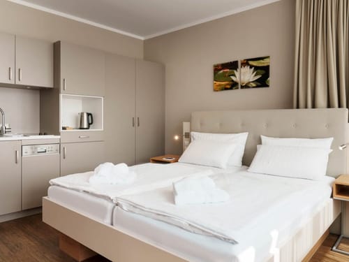 Modernes Hotelzimmer mit Küchenzeile und Doppelbett