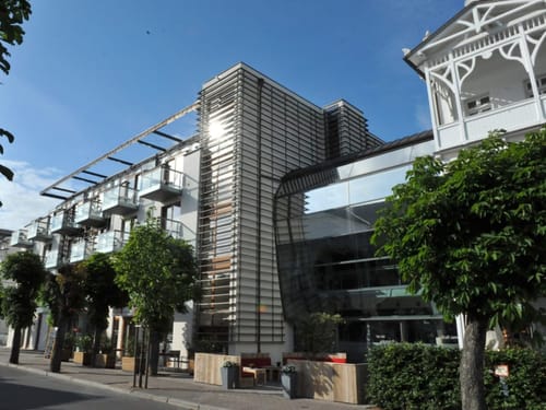 Moderne Architektur eines Hotels mit Glasfassade und Balkonen bei sonnigem Wetter