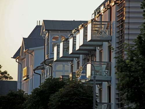 Moderne Architektur mit verglasten Balkonen in der Abenddämmerung.