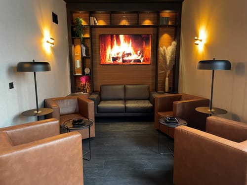 Gemütliche Lounge mit Ledersesseln und modernem Kunstkamin