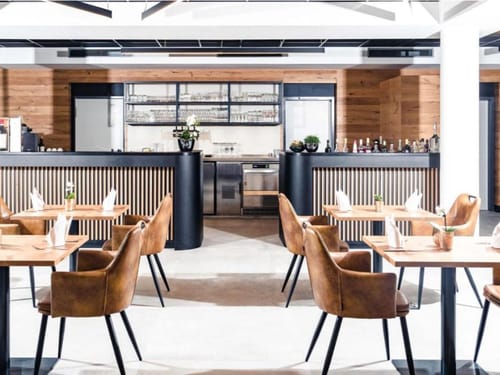 Modernes Restaurant mit eleganten Holzmöbeln und stilvoller Bar.