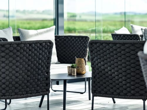 Moderne Outdoor-Lounge mit eleganten, geflochtenen Sesseln.