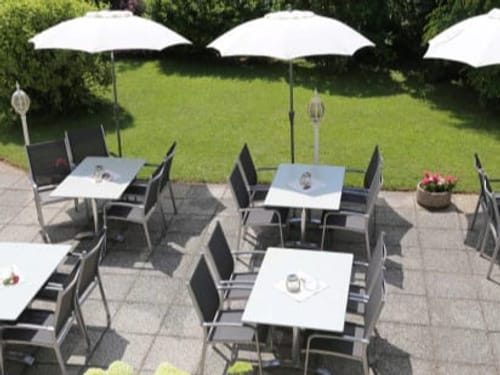 Außenterrasse mit Tischen und Stühlen im Garten