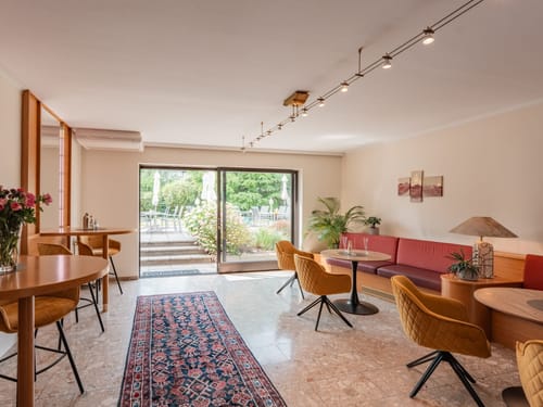 Gemütlicher Aufenthaltsraum mit modernem Design und Terrasse im Hintergrund