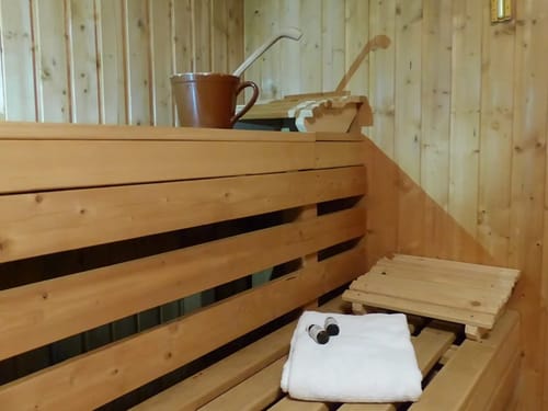 Traditionelle Holzsauna mit Handtuch und Aufgusseimer