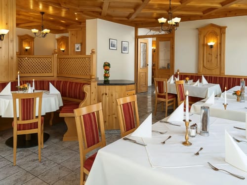 Elegantes Restaurant mit Holzmöbeln und gedeckten Tischen.