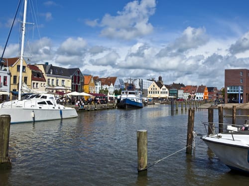 Malerischer Hafen mit bunten Häusern und Segelbooten in einer deutschen Küstenstadt