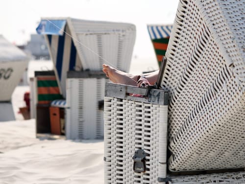 Strandkorb mit entspannten Füßen in den Dünen
