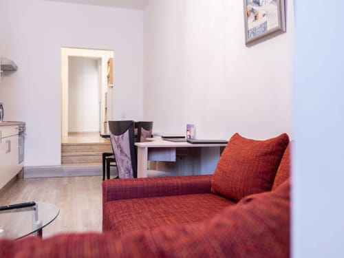 Gemütliches Wohnzimmer mit rotem Sofa und Essbereich