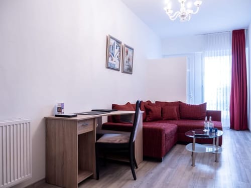 Modernes Wohnzimmer mit rotem Sofa und Schreibtisch