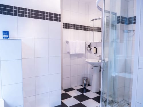 Modernes Badezimmer mit Duschkabine und weißer Fliesenverkleidung